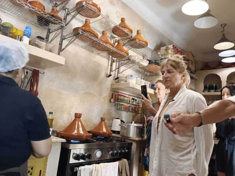 The guests are in the kitchen with Chef Sarah