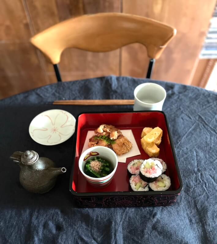 Sushi and karaage and side dishes in a traditional Wajima lacquer box